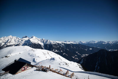 Scenic view of snowcapped mountains against clear blue sky