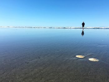 Scenic view of calm sea against clear blue sky