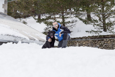 People on snow covered trees during winter