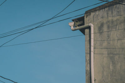 Low angle view of telephone pole against clear blue sky