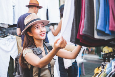 Portrait of smiling young woman standing at store