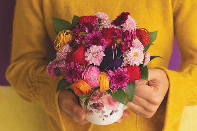 Decoration in a a cup of embroidery thread, needles and flowers