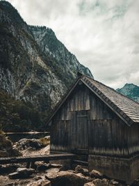 Built structure on land by mountain against sky