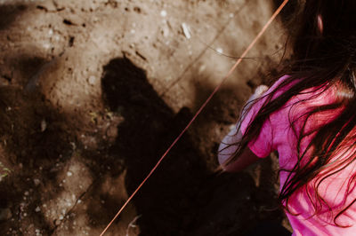 Midsection of girl planting on field