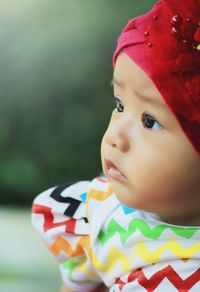 Close-up of cute baby girl looking away