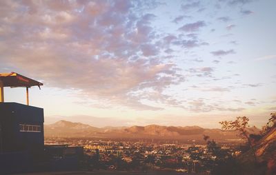 Scenic view of mountains against cloudy sky at sunset