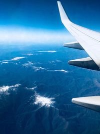 Aerial view of airplane flying over blue sky