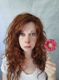 Portrait of young woman holding flower