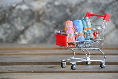 Close-up of rolled paper currency in small shopping cart on table