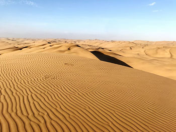 Sand dunes in desert against sky