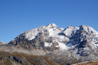 Snowcapped mountains against clear blue sky