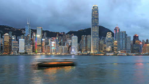 Blurred motion of boat sailing at victoria harbour against two international finance center