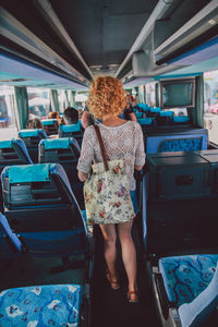 Full length of woman standing in bus