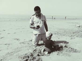 Full length of man photographing on beach