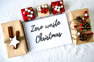 Zero waste christmas text with presents with decorations on white snow background. copy space. 