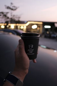 Cropped hand of man holding coffee cup