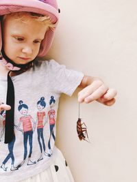 Full length of cute girl looking away against wall