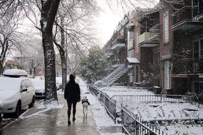 Rear view of man walking on snow covered road