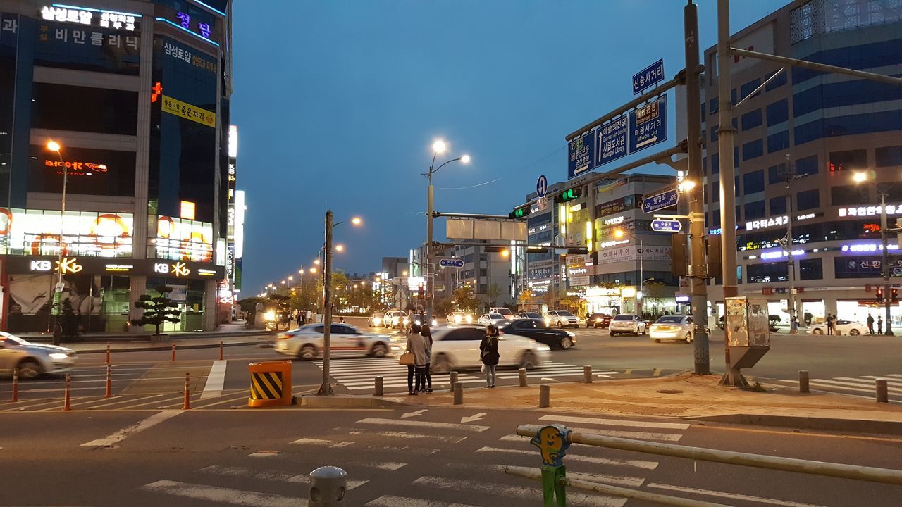 building exterior, architecture, built structure, city, night, illuminated, street, street light, city life, city street, building, sky, transportation, lighting equipment, residential building, car, incidental people, outdoors, residential structure, road