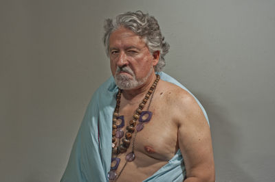 Portrait of shirtless man against gray background