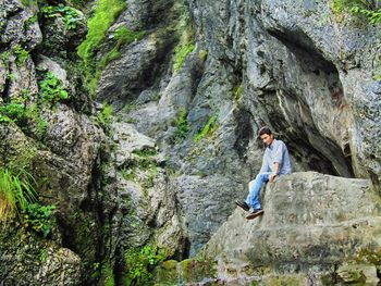 Woman standing on cliff against mountains