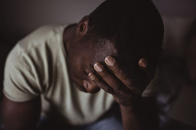 Close-up of man holding head in hand worriedly