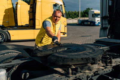 Side view of man repairing car