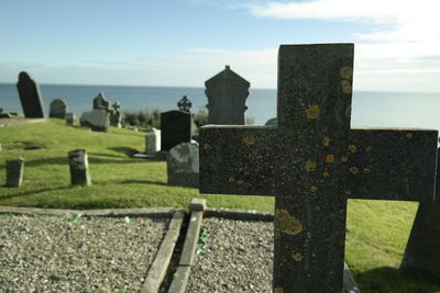 Cemetery by sea against sky