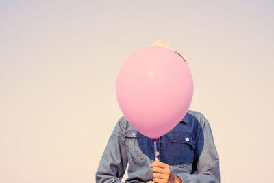Person holding balloons against white background