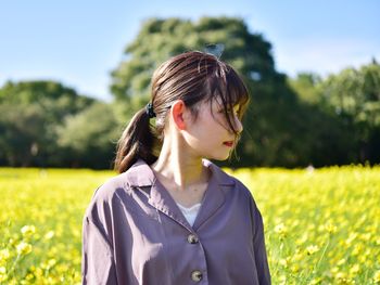 Portrait of young woman standing on field