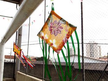 Multi colored flags hanging on metal fence