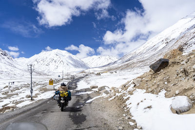 Indian biker riding a bike through the world highest motorable road khardungla pass in ladakh.