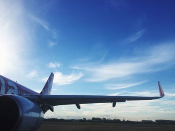 Airplane flying over runway against sky