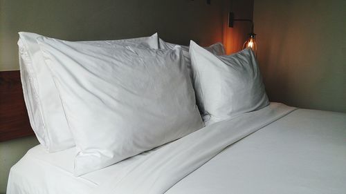 High angle view of pillows with sheet arranged on bed at home