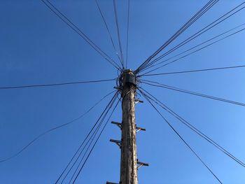 Low angle view of cables against clear blue sky