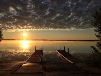 Jetty in sea against sunset sky