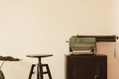 Typewriter on table against wall