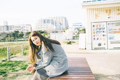 Portrait of young woman looking at city