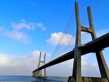 Low angle view of suspension bridge against sky. vasco da gama bridge, lisbon portugal. 