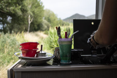 Close up of woman's hands washing dishes in motorhome.