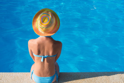 Rear view of woman in bikini swimming pool