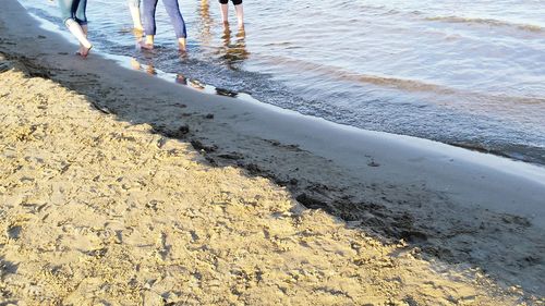 Low section of people standing on beach