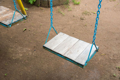 High angle view of empty swings hanging in park