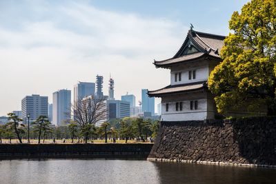 View of city by river against sky