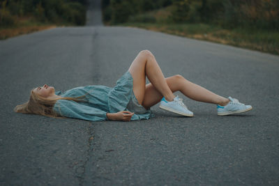 Woman lying on road in city