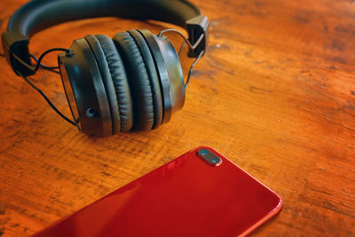 Close-up of mobile phone with headphones on table