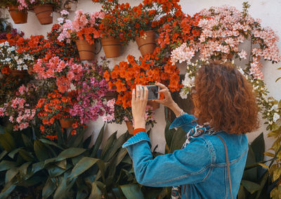 Portrait of woman photographing flowers