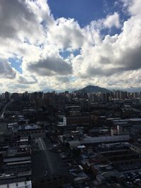 High angle view of cityscape against cloudy sky