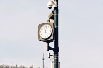 Low angle view of clock against clear sky