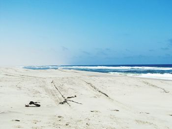 Scenic view of beach against blue sky